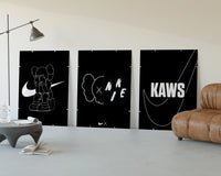 KAWS Nike Poster Set three-panel set displayed beside a brown leather sofa