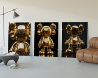 KAWS 24K Gold Figure Art Print Set of 3 displayed beside a brown leather sofa
