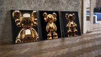 KAWS 24K Gold Figure Art Print Set of 3 leaning on parquet beside a vintage loft door