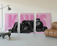 KAWS Pink Reclining Companion Set of 3 displayed beside a brown leather sofa