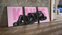 KAWS Pink Reclining Companion Set of 3 leaning on parquet beside a vintage loft door