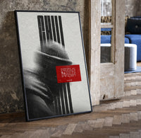 figure in helmet obscured by stripes print in a black frame leaning beside a vintage door on parquet