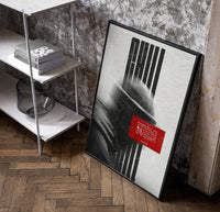 figure in helmet obscured by stripes poster in a black frame leaning beside a shelf in a raw-plaster loft