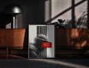 Black-framed figure in helmet obscured by stripes print on a moody console with designer coffee-table books