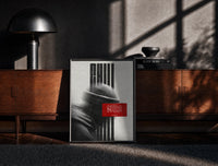Black-framed figure in helmet obscured by stripes print on a moody console with designer coffee-table books