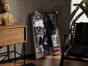 Walnut-framed Itachi Uchiha anime character print leaning against a sunlit rustic brick wall