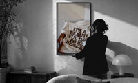 It's a Beautiful Day to Be Black print in a slim black frame being hung on a sunlit wall in a monochrome room