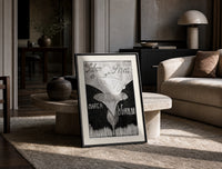 Baby cherub sitting on flower print in a black frame leaning on a travertine table in a sunlit lounge