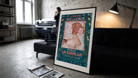 Art Nouveau woman in profile print in a slim black frame leaning on a dark sofa in a concrete print studio