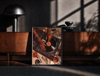 Black-framed Jeweled Hands on a Record Player print on the floor in front of a dark wooden console