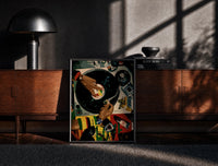 Black-framed Jeweled Hands on a Turntable print on the floor in front of a dark wooden console