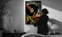 Jeweled Hands on a Turntable print in a slim black frame being hung on a sunlit wall in a monochrome room