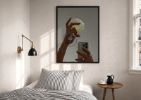 Jeweled Hands with Phone and Glass print in a black frame above a bed with striped linens