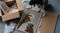 Jeweled Hands with Phone and Glass framed print being unpacked from protective bubble wrap and a box
