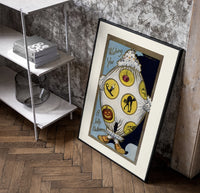Vintage Halloween clown holding sheet poster in a black frame leaning beside a shelf in a raw-plaster loft
