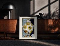 Black-framed Vintage Halloween clown holding sheet print on a moody console with designer coffee-table books