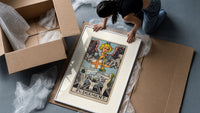 Angel blowing trumpet over rising figures framed print being unpacked from protective bubble wrap and a box