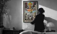 Judgement print in a slim black frame being hung on a sunlit wall in a monochrome room