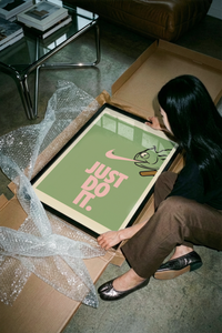 Chameleon poster with pink lettering leaning on a cardboard shipping tube against gray