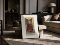 Justice tarot card figure print in a black frame leaning on a travertine table in a sunlit lounge