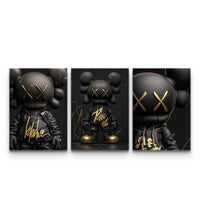 Three-panel KAWS Black Label XX poster set with matte black figures and gold XX accents on a dark background