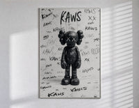 Black and white KAWS graffiti framed poster poster in a slim frame on a bright wall with soft window light