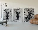 KAWS Companion figure three-panel set displayed beside a brown leather sofa