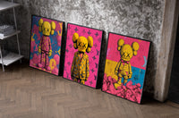 KAWS Companion figures triptych set of three black-framed prints leaning against a raw-plaster wall