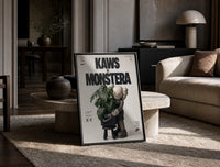 KAWS Companion figure holding monstera plant print in a black frame leaning on a travertine table in a sunlit lounge