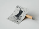 Rolled KAWS Companion figure sitting poster beside its crush-resistant kraft shipping tube