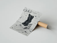 Rolled KAWS Companion figure sitting poster beside its crush-resistant kraft shipping tube