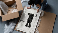 KAWS Companion Passing Through figure framed print being unpacked from protective bubble wrap and a box