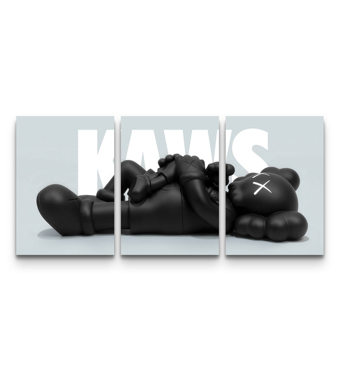 Full three-panel KAWS Companion lounge poster set with a reclining black figure spread across a grey backdrop