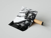 Reclining KAWS companion against sweeping silver paint splash on a monochrome print resting on a cardboard tube