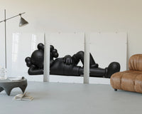 Triptych of the Black stylized cartoon character figures in reclined poses displayed above a couch