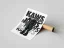 KAWS standing figure with stacked fading KAWS typography rolled art print beside cardboard packaging tube