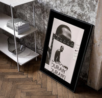 Kevin Durant basketball player portrait poster in a black frame leaning beside a shelf in a raw-plaster loft