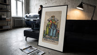 King of Cups tarot figure print in a slim black frame leaning on a dark sofa in a concrete print studio
