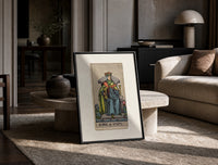 King of Cups tarot figure print in a black frame leaning on a travertine table in a sunlit lounge