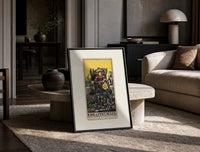 King of Pentacles tarot figure print in a black frame leaning on a travertine table in a sunlit lounge