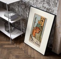 King seated on throne with staff poster in a black frame leaning beside a shelf in a raw-plaster loft