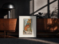 Black-framed King seated on throne with staff print on a moody console with designer coffee-table books