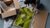 Kiwi Fruit Slices framed print being unpacked from protective bubble wrap and a box