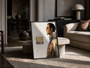 Man in profile with sunglasses print in a black frame leaning on a travertine table in a sunlit lounge