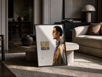 Man in profile with sunglasses print in a black frame leaning on a travertine table in a sunlit lounge
