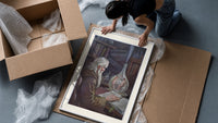 Old alchemist reading book with flask framed print being unpacked from protective bubble wrap and a box