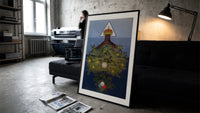 Inverted tree with crown print in a slim black frame leaning on a dark sofa in a concrete print studio