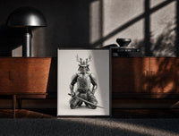 Black-framed Skeletal samurai in metallic armor print on a moody console with designer coffee-table books