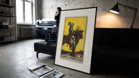 Knight on horse holding pentacle print in a slim black frame leaning on a dark sofa in a concrete print studio