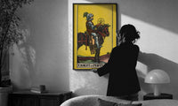 Knight of Pentacles print in a slim black frame being hung on a sunlit wall in a monochrome room